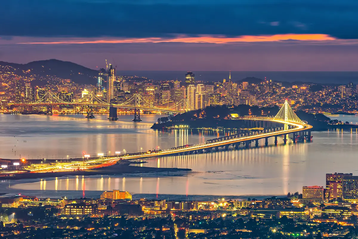 san francisco skyline and bay bridge at sunset